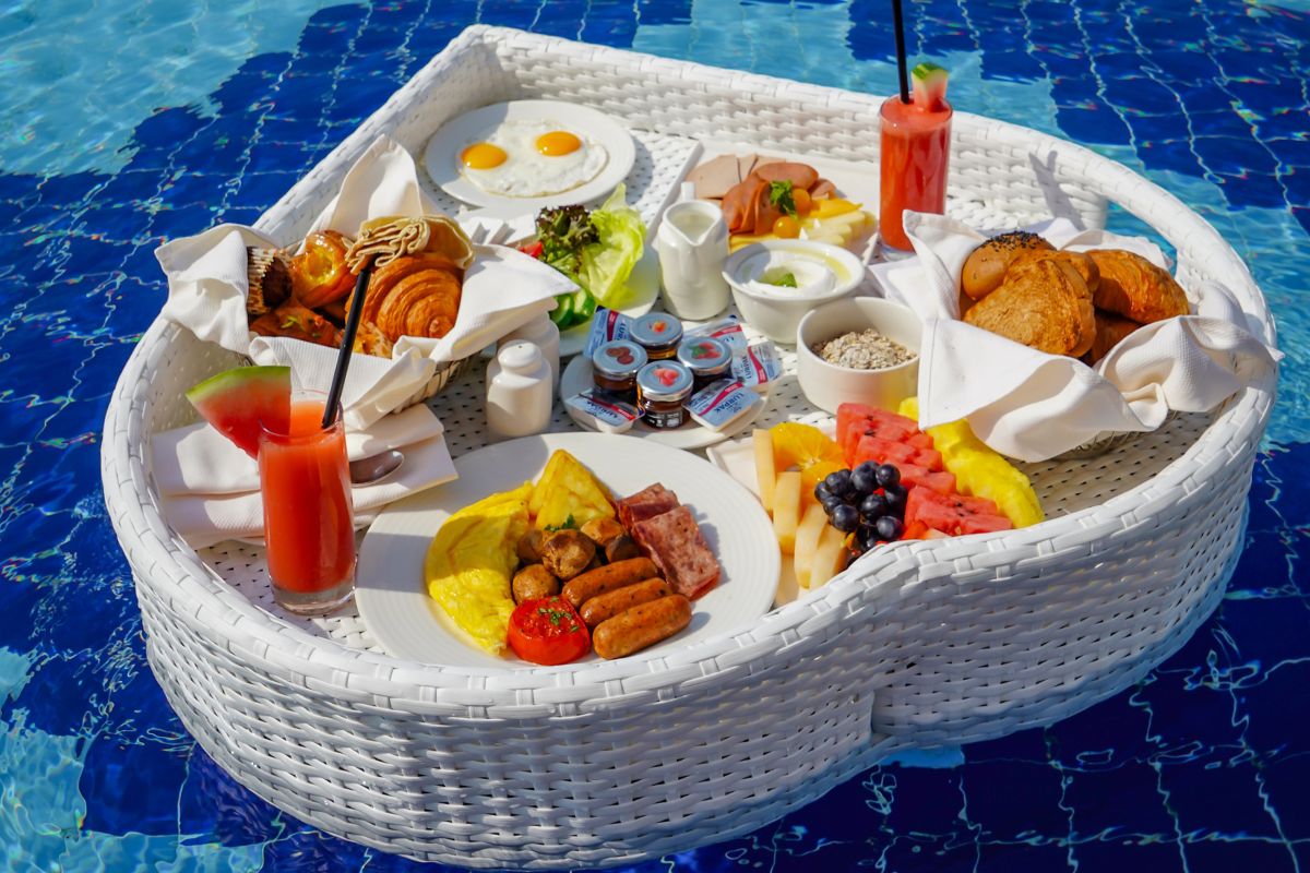 Royal M Hotel by Gewan Abu Dhabi floating breakfast tray that includes a watermelon juice, full english breakfast with an omelette, eggs, croissants, patries, fruit platter and more for the best breafkast offers in Abu Dhabi